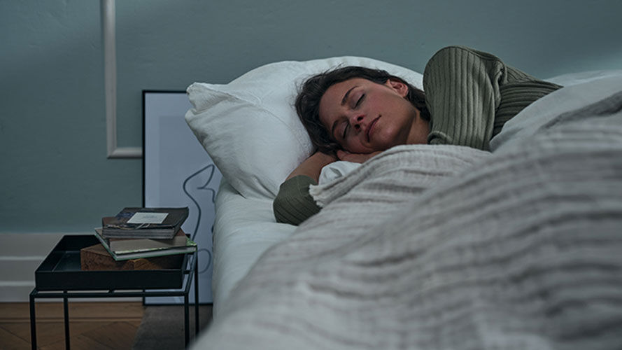 Een vrouw ligt in bed en slaapt.
